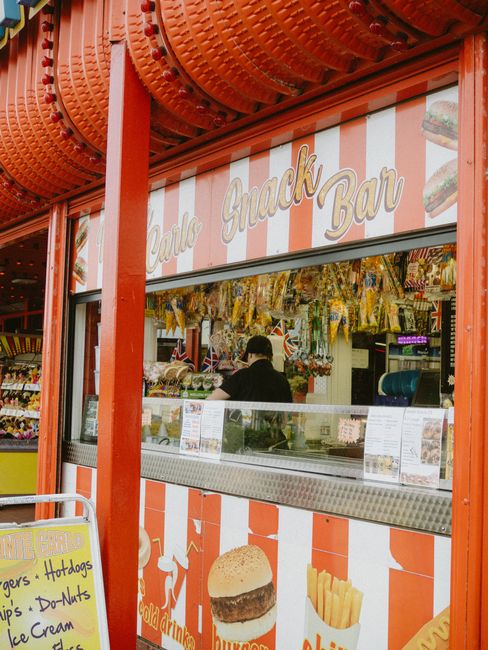 A vibrant snack bar with red and white striped decor, offering a variety of snacks and drinks.