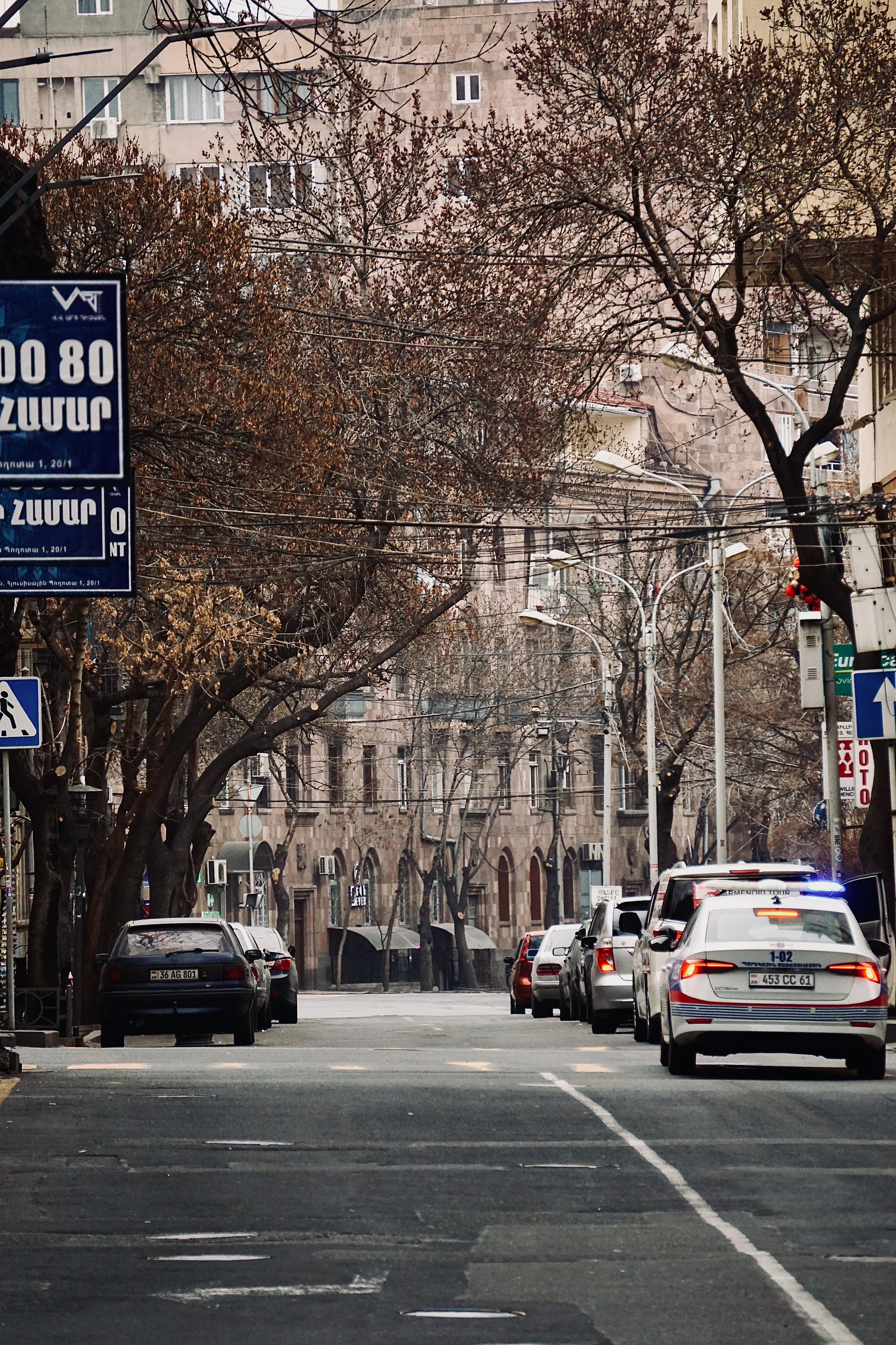 A city street lined with cars and buildings, showcasing urban architecture and traffic.