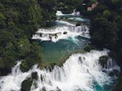 这张令人惊叹的航拍照片捕捉到了被青翠树木环绕的瀑布，展现了大自然的宁静之美