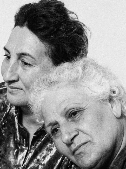 Intimate black and white portrait of two elderly women embracing friendship and warmth.