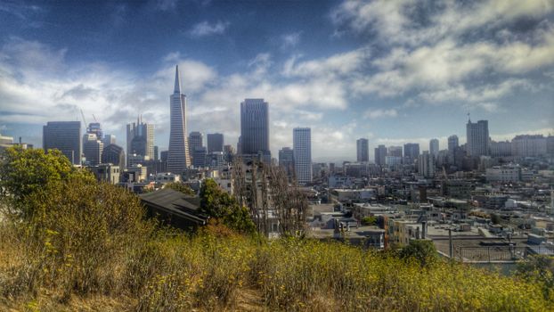 A panoramic view of San Francisco's iconic skyline featuring the Transamerica Pyramid on a cloudy day.