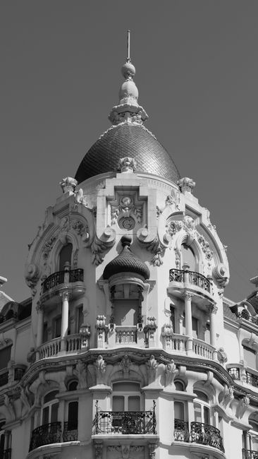 Black and white photo highlighting the intricate facade of a historic Madrid tower.
