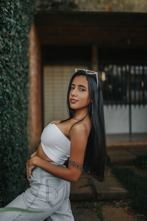 Free Fashionable woman with long hair and tattoos posing in sunglasses outdoors. Stock Photo