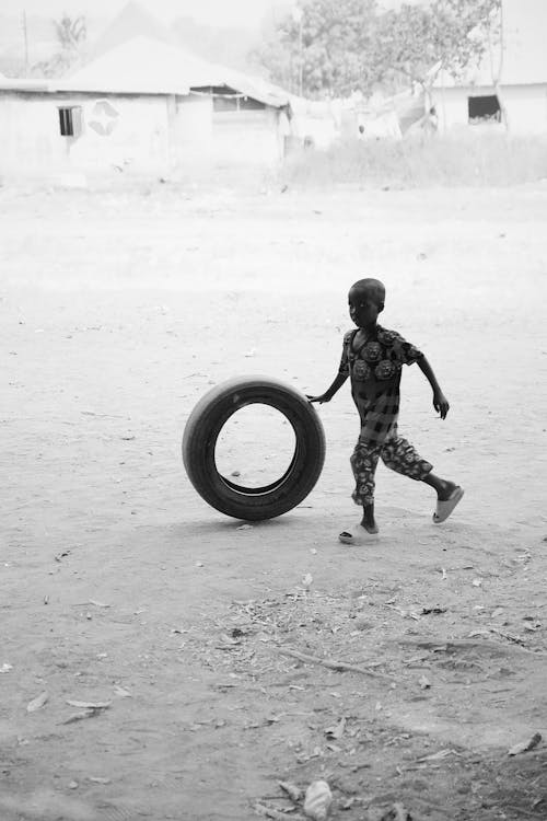 Boy Running and Rolling Tire