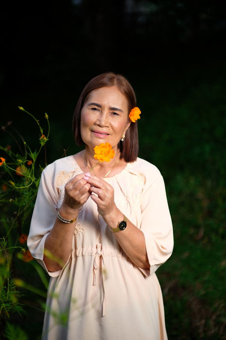 Woman Standing And Posing With A Flower In Her Hand 