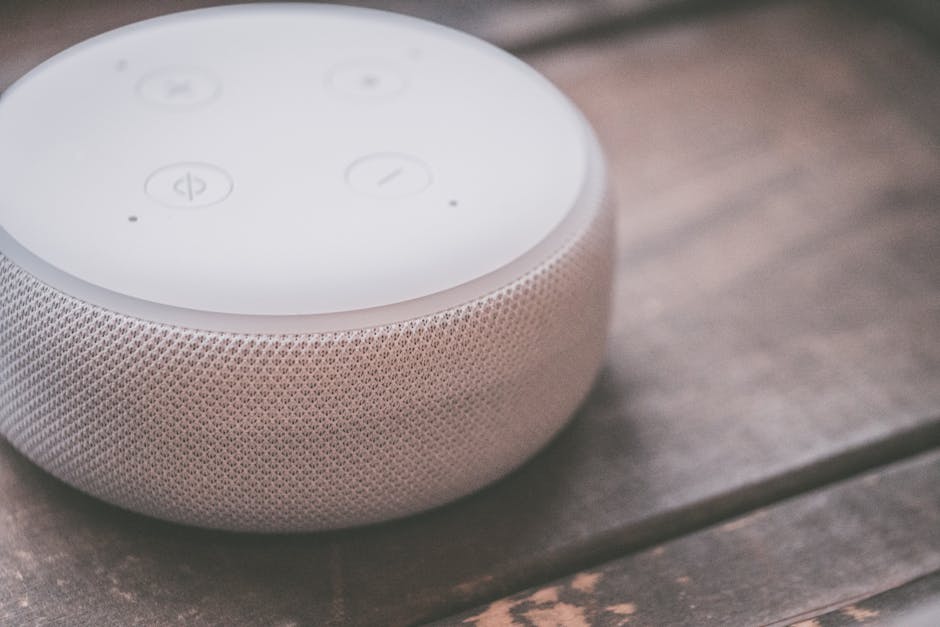 Google home speaker on a dark brown wood table.  Breakthroughs in AI and voice tech are taking place currently.