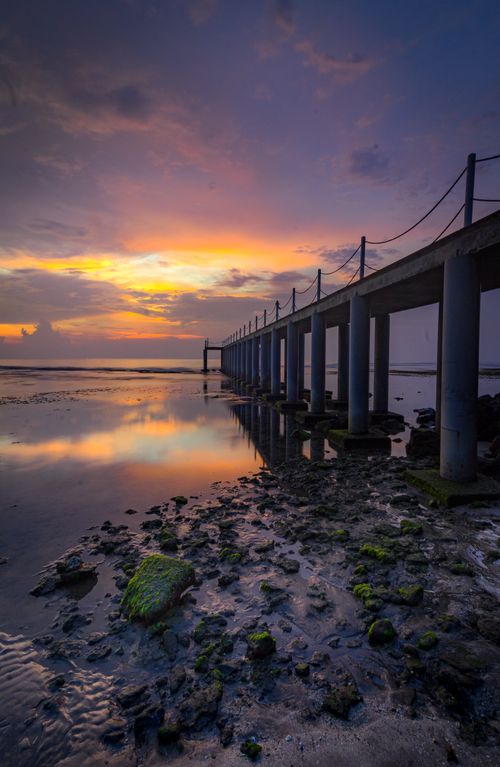 Free Stunning sunset over a pier in Banten, Indonesia with vibrant reflections. Stock Photo