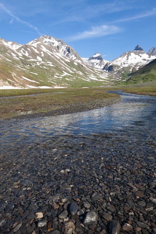 Free Breathtaking view of La Grave's alpine landscape with a serene stream and majestic mountains. Stock Photo