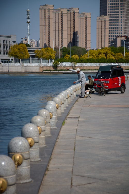 Man with a Red Vehicle by the River in Baku 