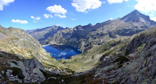 Lago Rodeado Por La Cima De La Montaña Bajo Un Cielo Azul Durante El Día