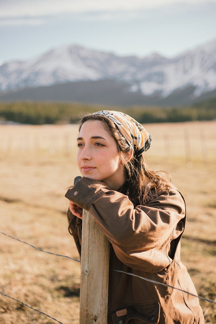 Woman Leaning On Wooden Post