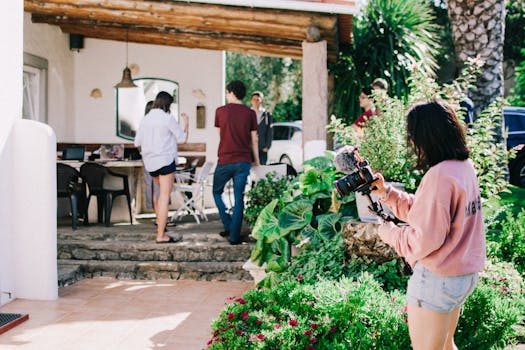 A group of friends enjoying leisure time and photography in a sunny garden setting.