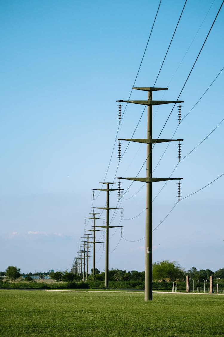 Electricity Poles On A Field 