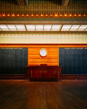 Elegant interior of the Chicago Stock Exchange Trading Room featuring a vintage clock and wooden décor.