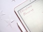 平板电脑顶视图，白色表面带有星星和圣诞节规划模板