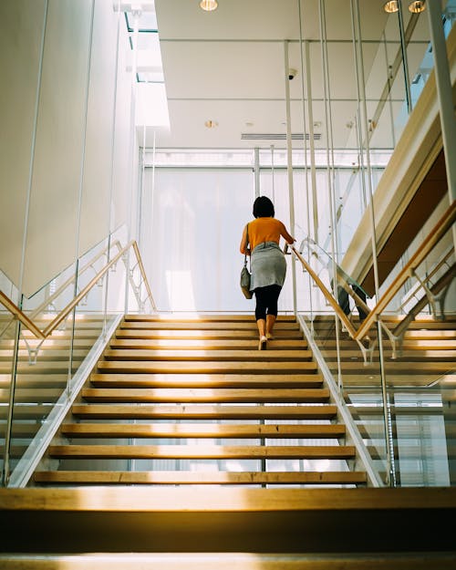 бесплатная Женщина идет по коричневой лестнице Стоковое фото
