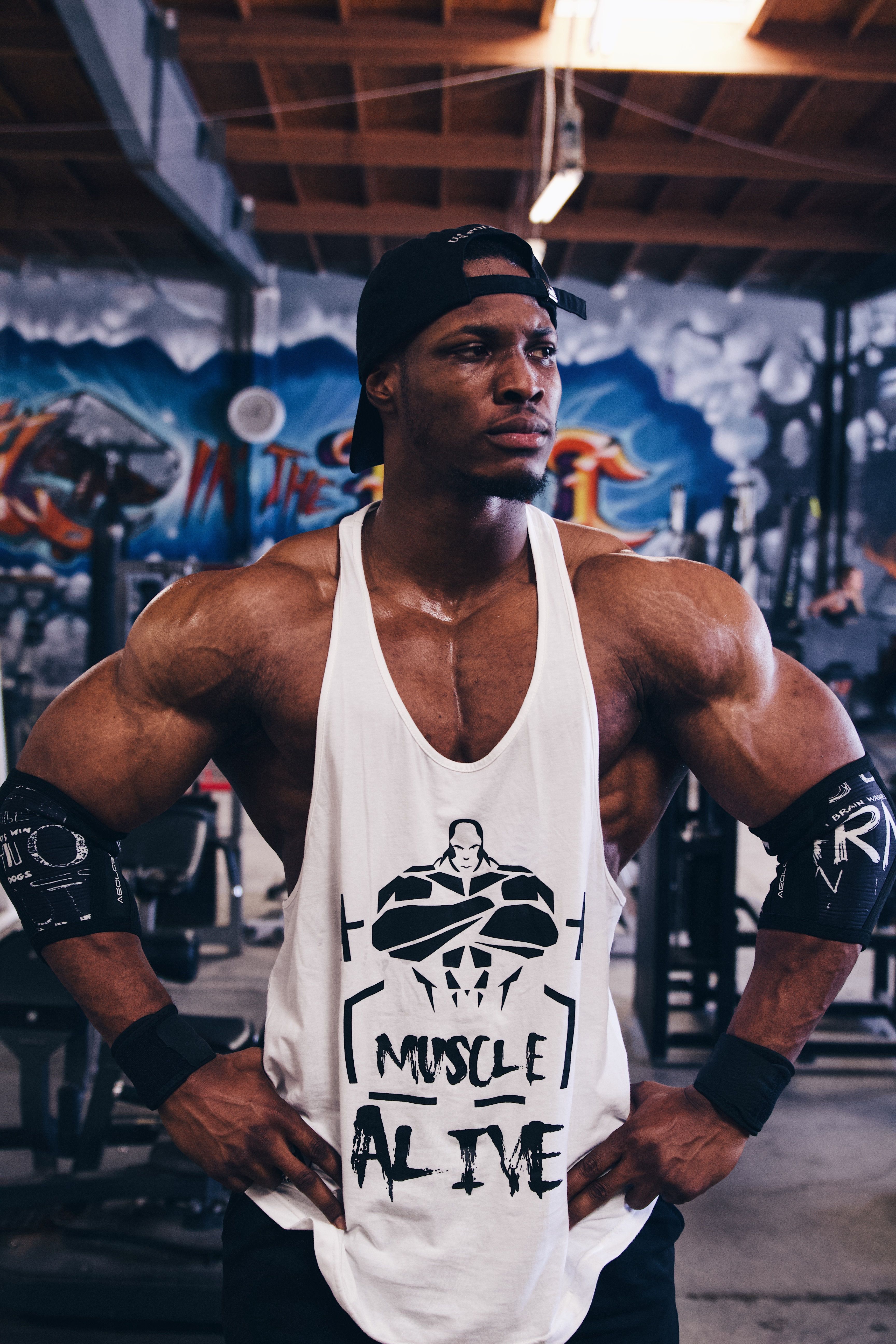 Focused African American bodybuilder posing confidently in a gym setting, showcasing strength.