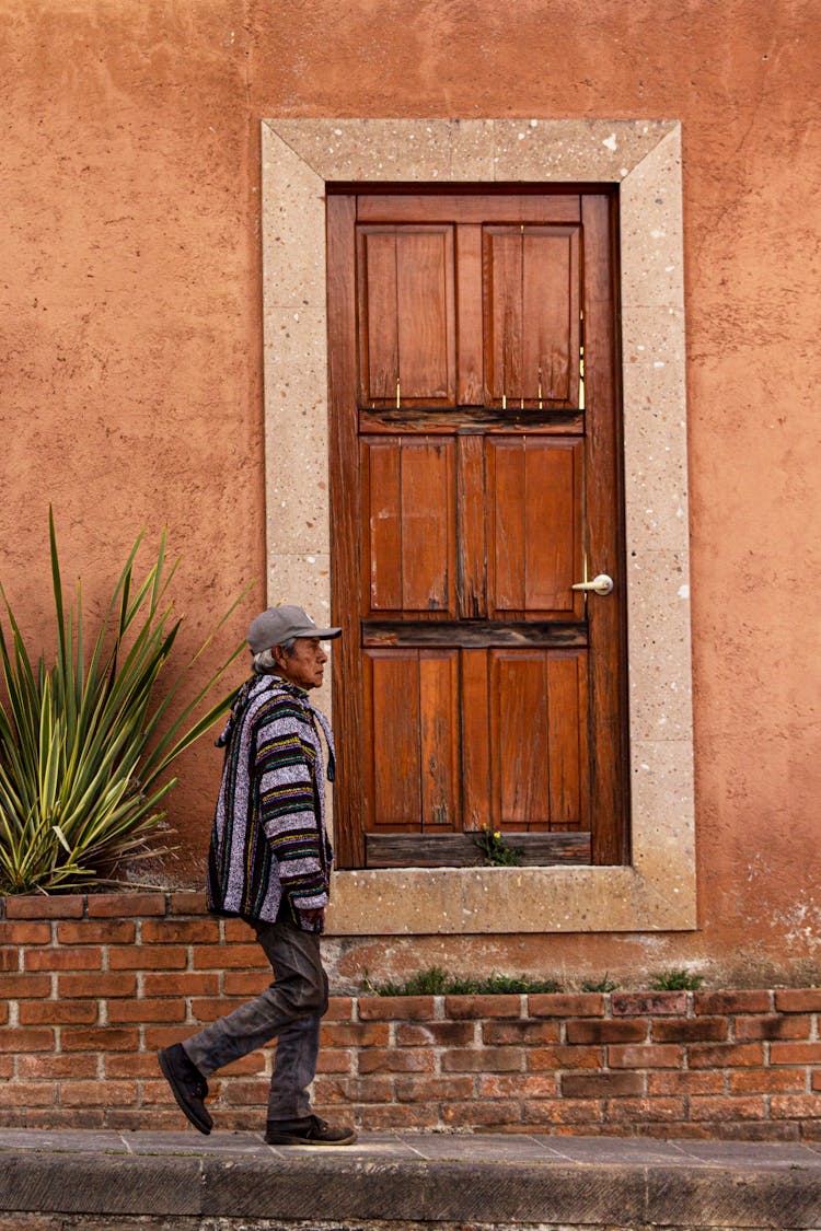 Man Walking Near Wooden Door