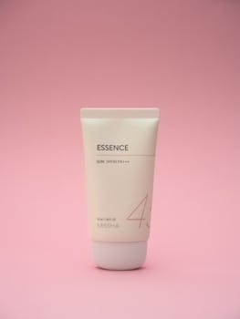Minimalist skincare tube on pink backdrop, ideal for beauty and healthcare themes.
