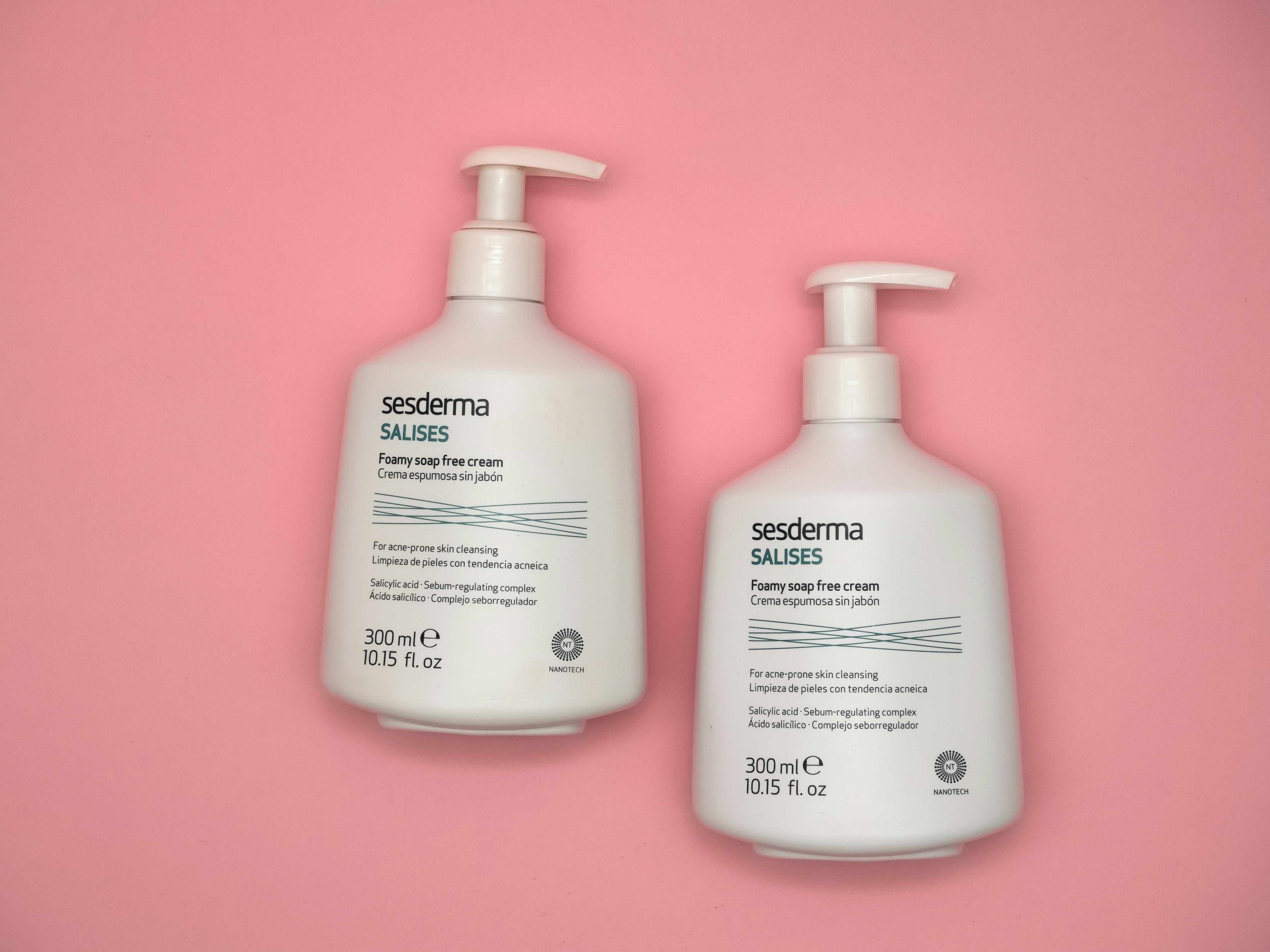 Top view of Sesderma Salises foamy soap-free cream bottles against a pink backdrop.