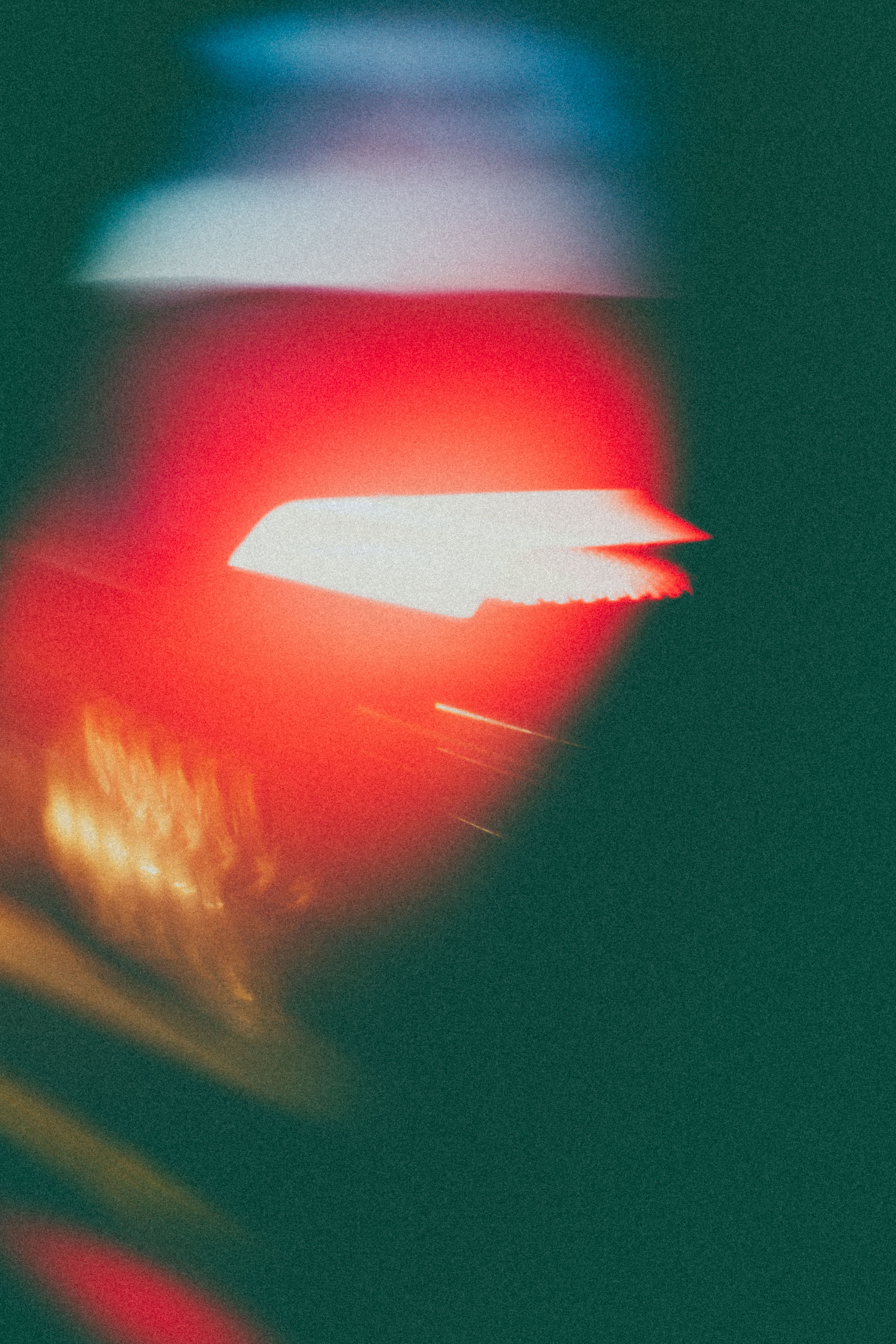 Blurred motion of a car's illuminated rear light, creating an abstract effect.