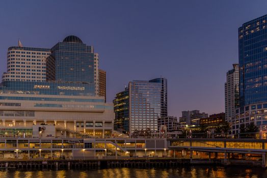 Modern Vancouver skyline at dusk with urban waterfront view, showcasing iconic architecture and cityscape reflections.