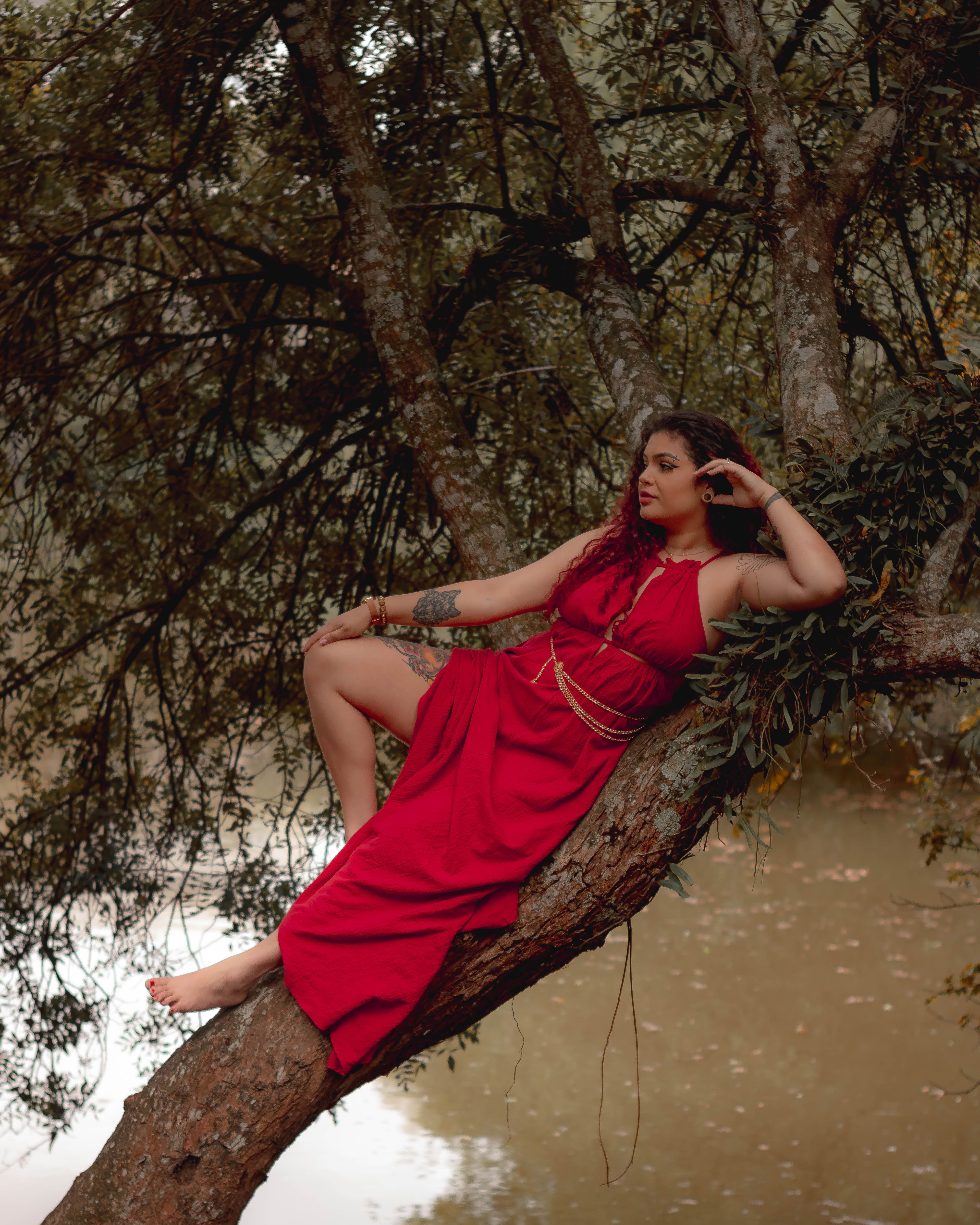 Young Woman in a Long Red Dress Posing Outdoors · Free Stock Photo