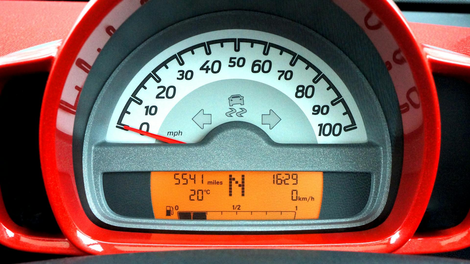 Detailed view of a car's speedometer and digital dashboard display with various indicators.