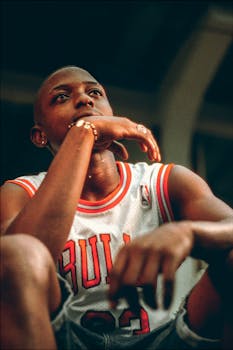 Close-up portrait of a basketball player in a reflective pose outdoors.