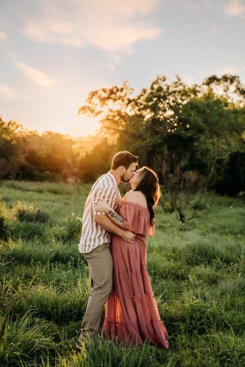 Couple Kissing on Grassland at Sunset