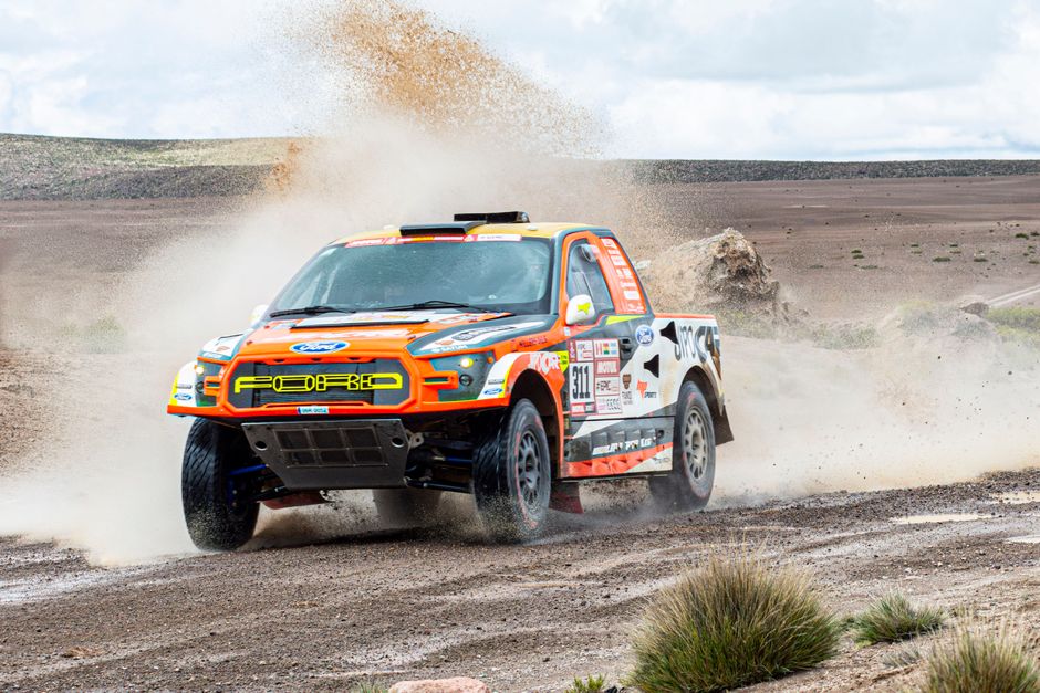 A modified off-road Ford truck racing across the rugged desert terrain in Arequipa, Peru.