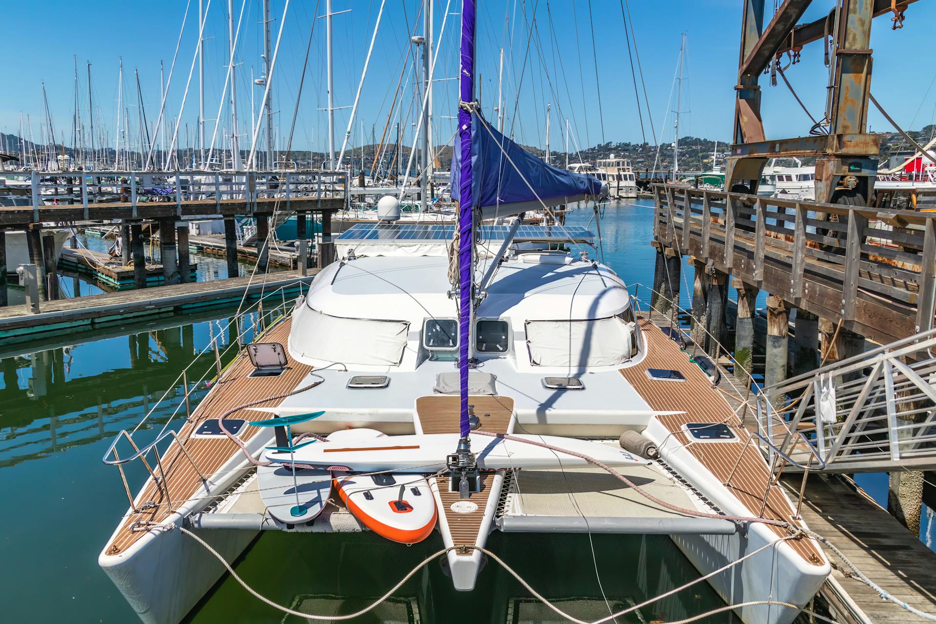 Catamaran docked in a sunny marina with clear blue skies, perfect for nautical adventures.