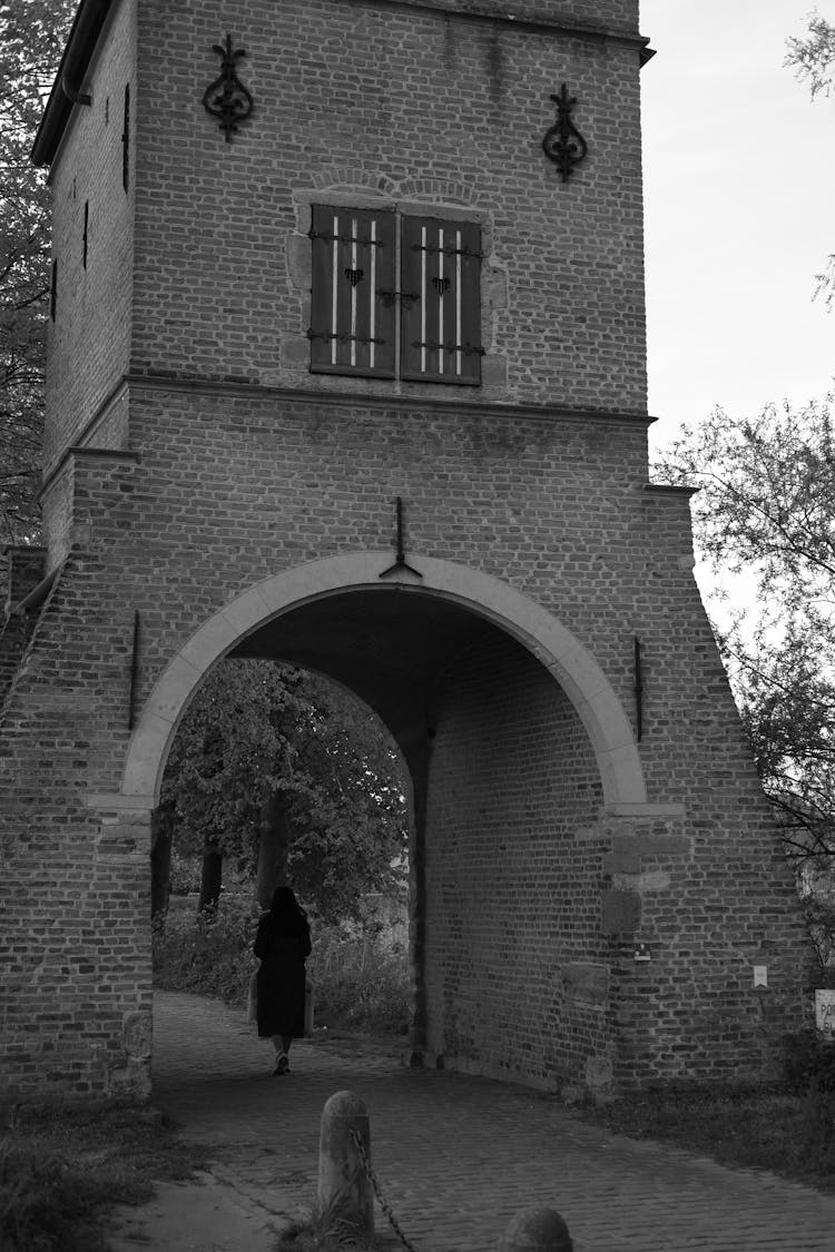 Black And White Photo Of A Woman Silhouette In A Castle Entrance Arch