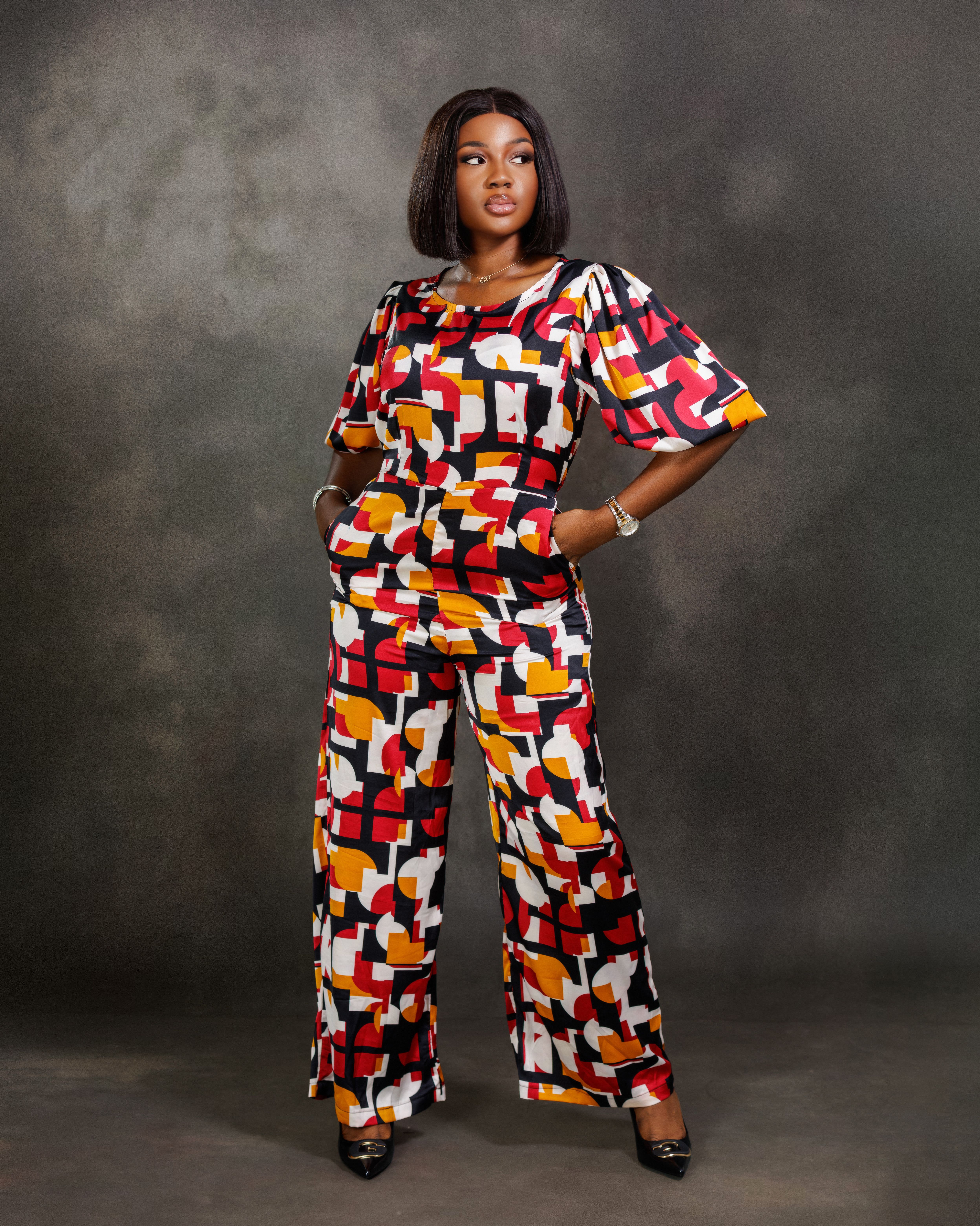 African woman in vibrant patterned outfit posing confidently in studio — Ali Drabo on Pexels