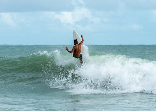 Homem Andando De Prancha De Surfe No Corpo D'água