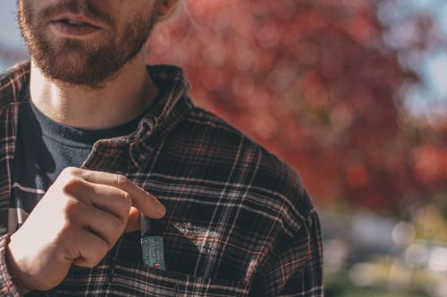 Free Close-up of a bearded man wearing a flannel shirt outdoors during a sunny day. Stock Photo
