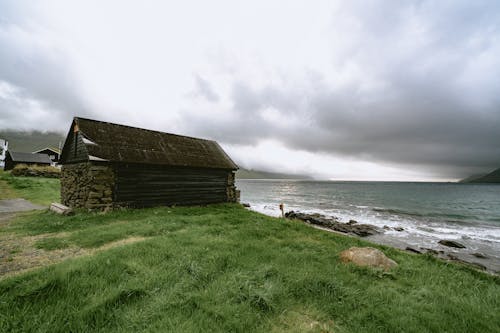 Farmhouse on a Lakeshore under a Stormy Sky 