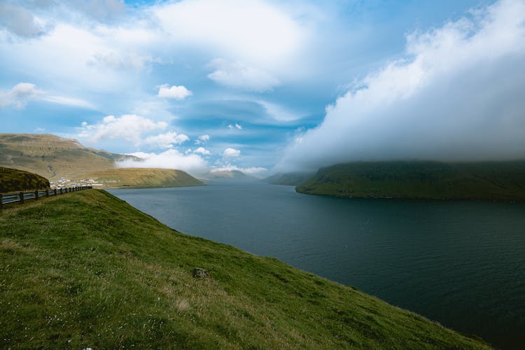 Scenic View Of Lake And Green Hills 