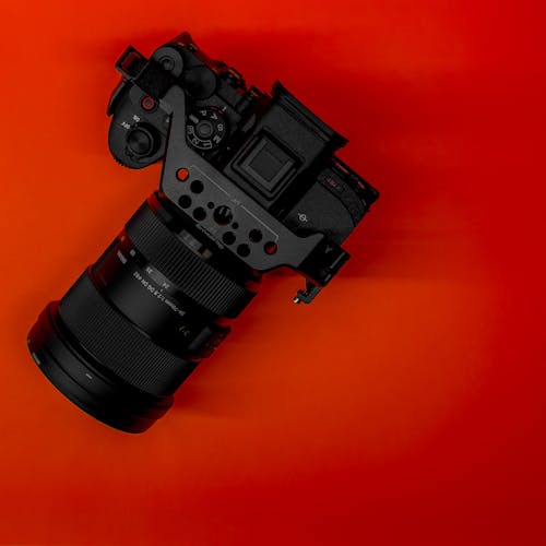Close-up of a Professional SLR Camera Standing on Red Background 