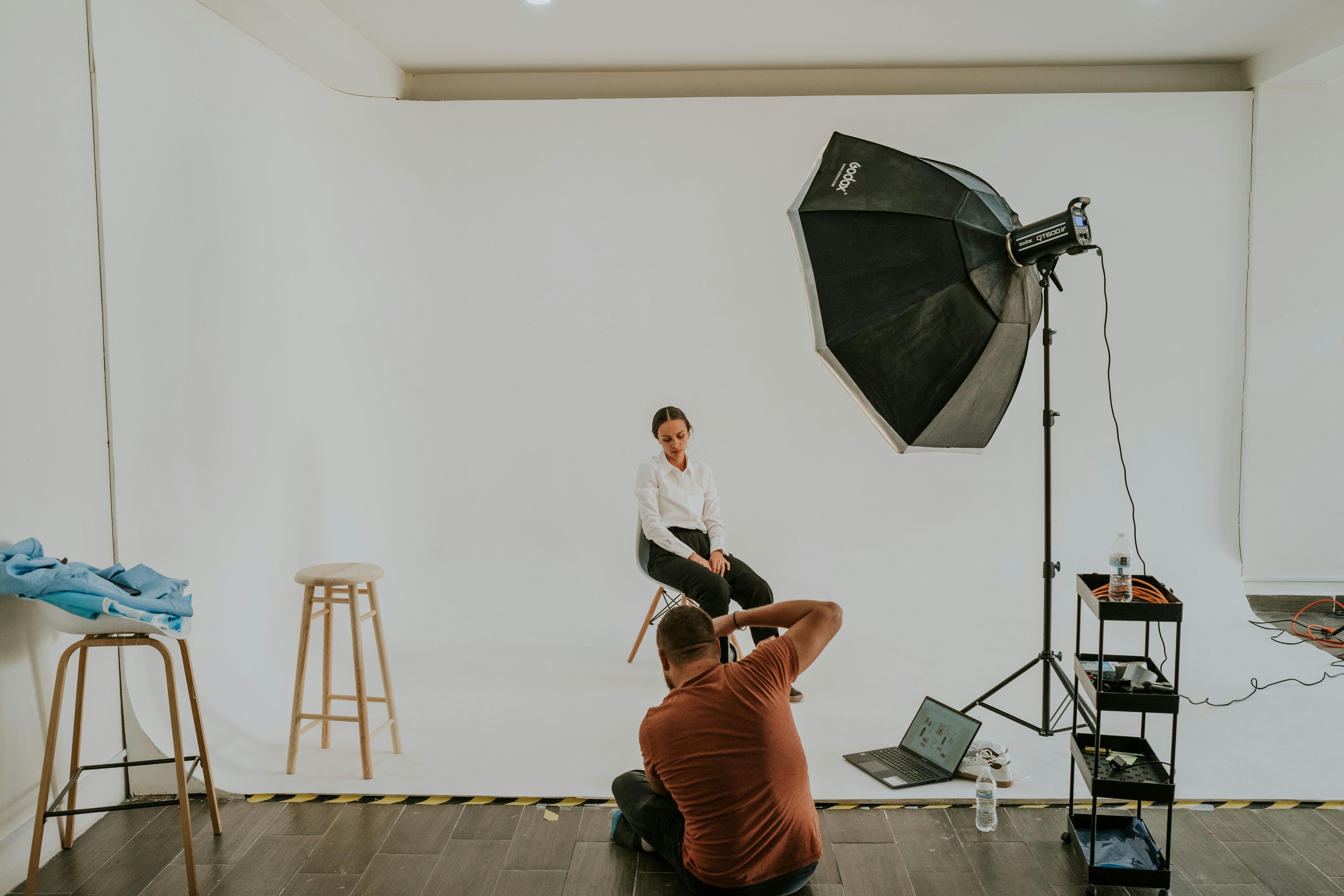 Photographer capturing a model in a professional studio environment with lighting setup.