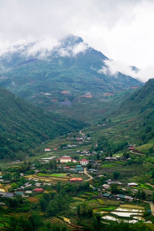 Free A picturesque rural village nestled in lush green mountains and terraced fields. Stock Photo