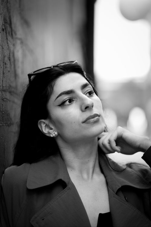 Free A black and white portrait of a woman posing thoughtfully against a textured wall. Stock Photo