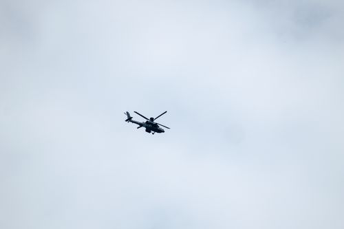 Free A military helicopter flying against an overcast sky, showcasing aerial technology. Stock Photo