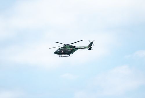 Free A military helicopter in flight against a bright blue sky, showcasing army aviation technology. Stock Photo