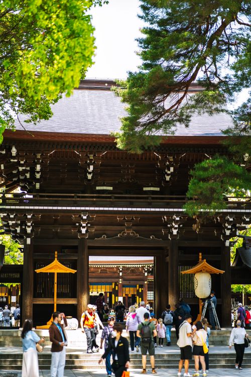 Free Visitors exploring the historic Meiji Shrine in Tokyo, surrounded by lush greenery. Stock Photo