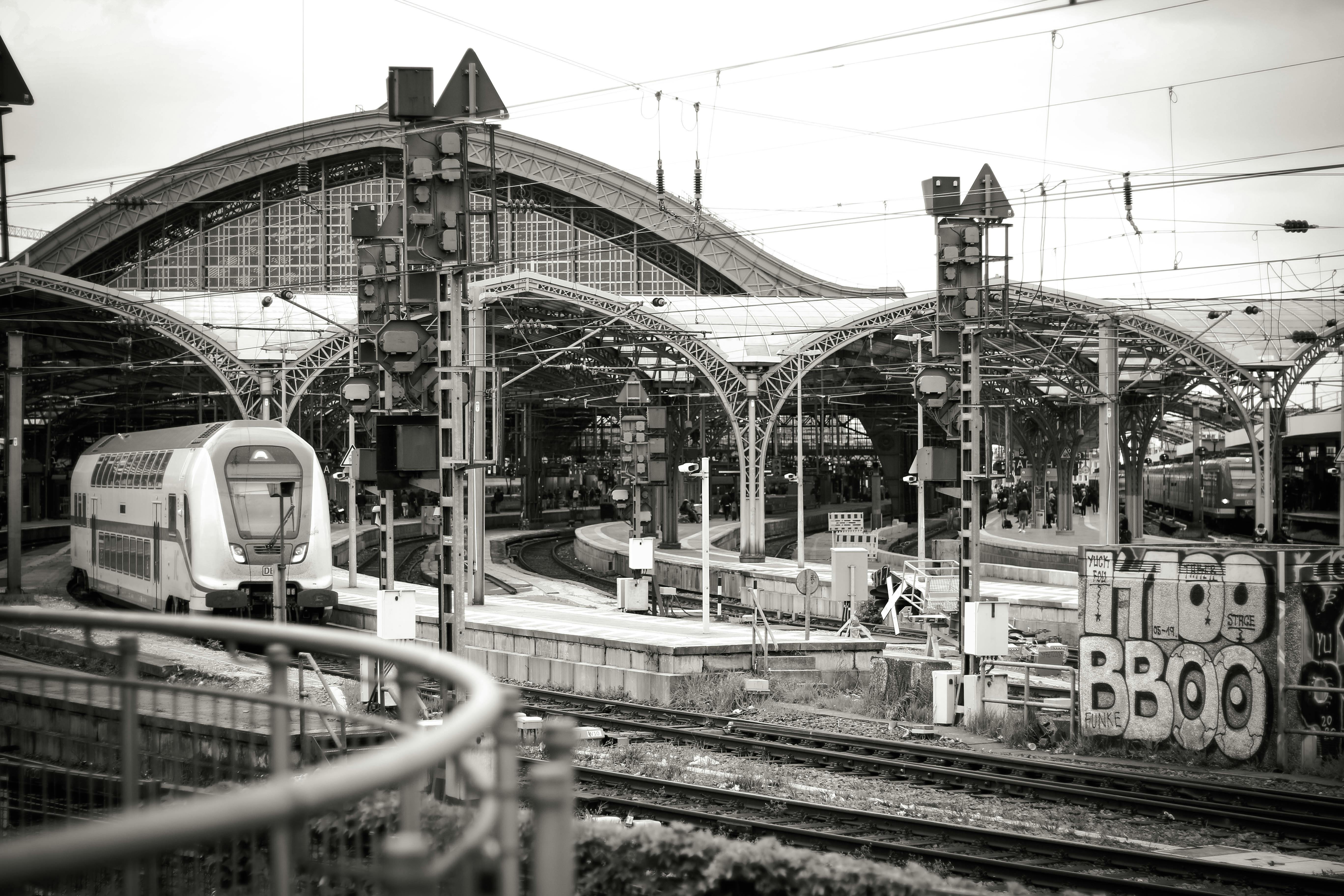 Elegant black and white photo of Cologne Central Station showcasing architecture and transportation.