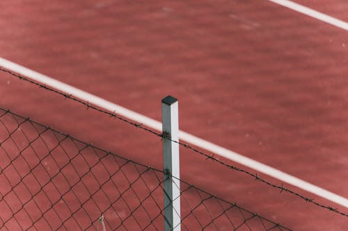 Metal Fence with Barbed Wire at a Tennis Court