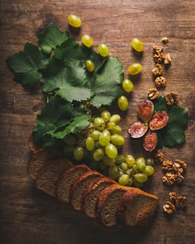 一幅描绘木桌上葡萄、切片面包、无花果和核桃的乡村静物画