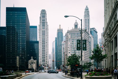 Free View of a bustling city street surrounded by modern skyscrapers and historic architecture. Stock Photo