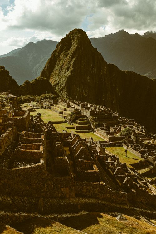 Free Stunning aerial view of the ancient Incan ruins of Machu Picchu in Peru under cloudy skies. Stock Photo
